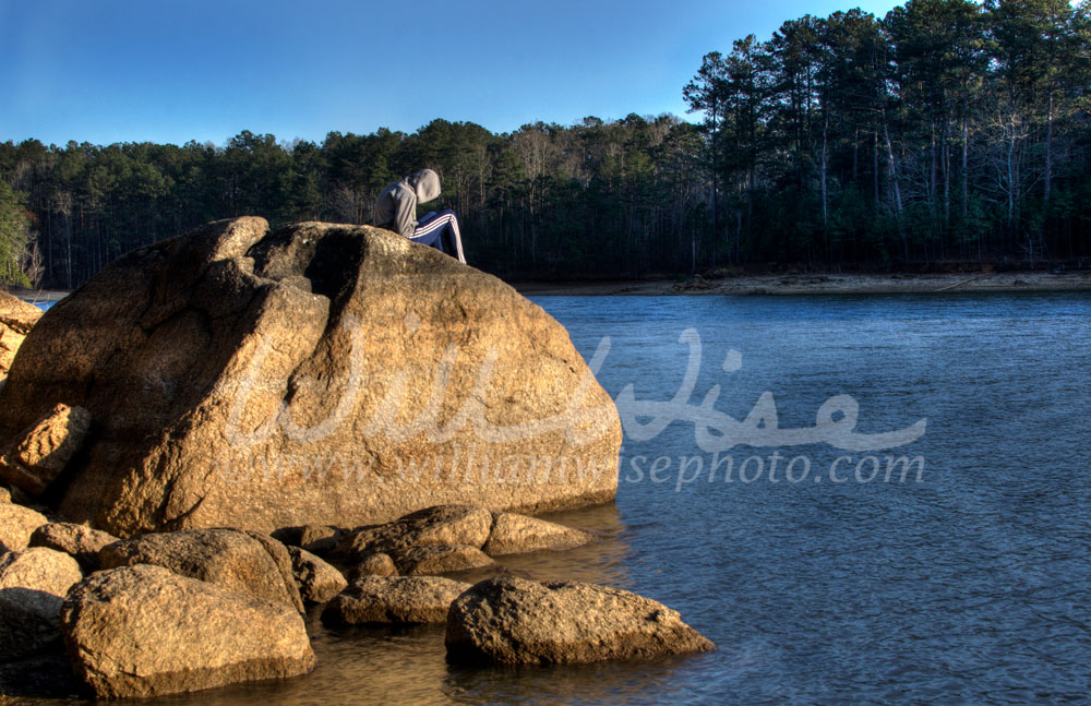 Lonely teen in hoodie texting on cell phone, Lake Allatoona, Red Top Mountain State Park, Georgia, USA Picture